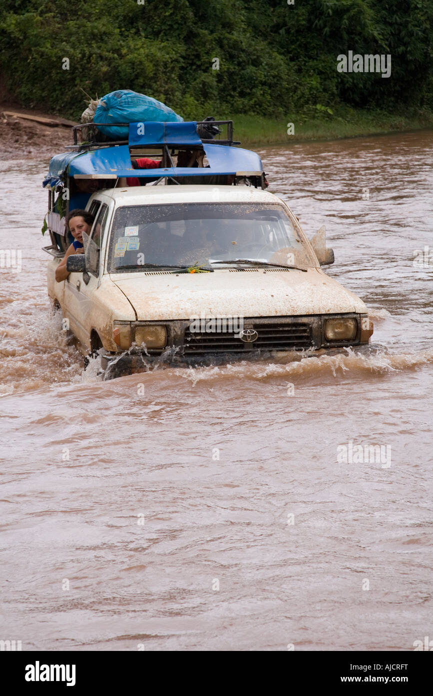 Four wheel drive vehicle crosses river at The Gibbon Experience near Huay Xai on the Mekong river near the Laos Thai border Stock Photo