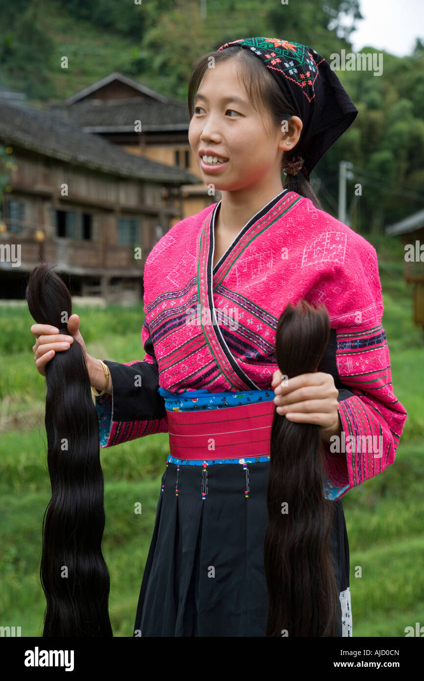 A Red Yao girl holds two new braids of hair to be added to a woman s mane  of already long hair Guilin China Stock Photo - Alamy