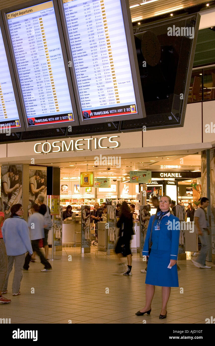 Flight attendant reads schedule board at Schiphol Airport terminal in Amsterdam Netherlands Stock Photo
