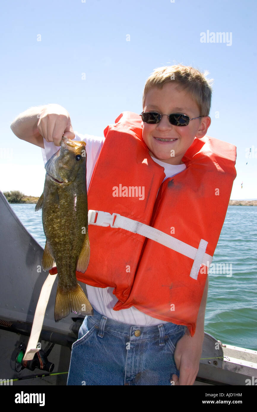 A twelve year old boy wearing a life jacket and holding a bass he caught  while fishing in Idaho MR Stock Photo - Alamy