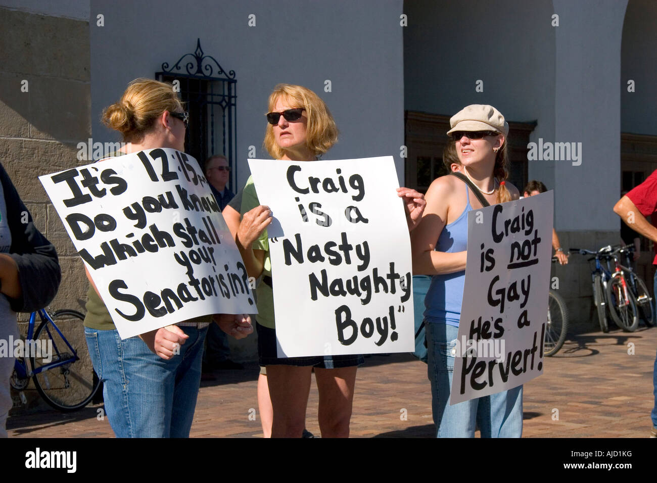 Women hold signs protesting Idaho Senator Larry Craig in Boise Idaho Stock Photo
