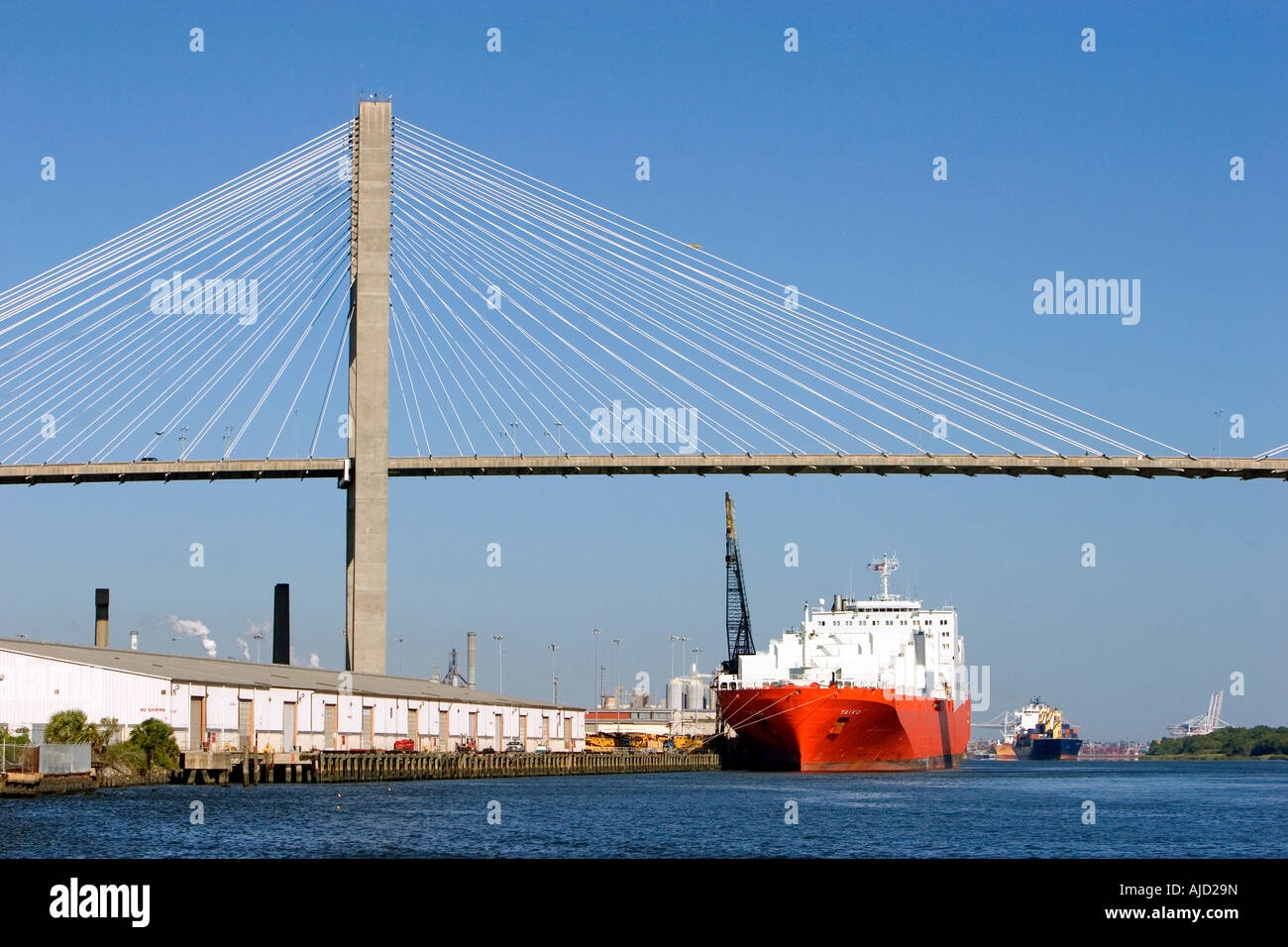 Container ships pass under the Talmadge Memorial Bridge on the Savannah River at the Port of Savannah in Savannah Georgia Stock Photo