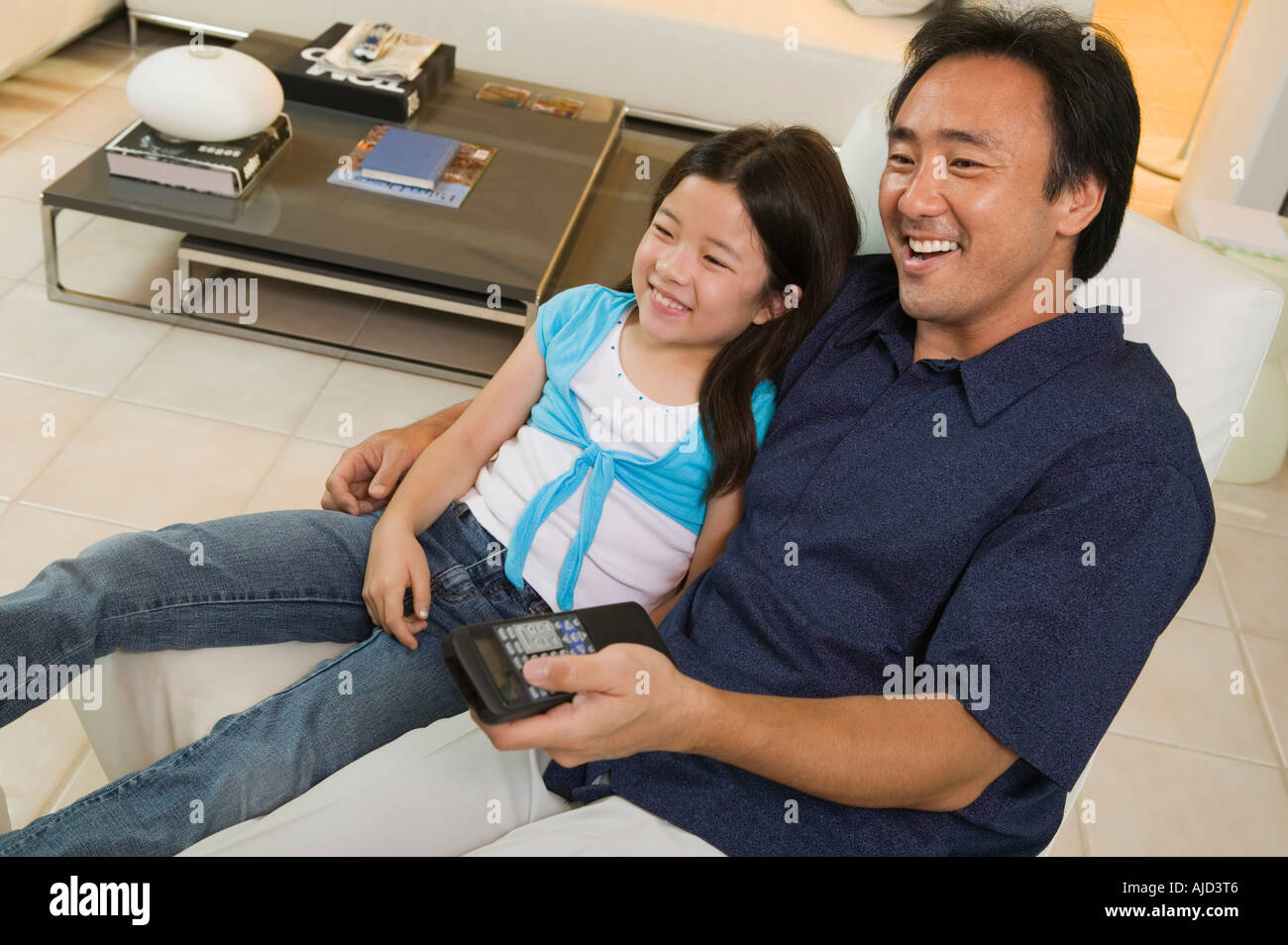 Father and Daughter Watching TV Together in living room, high angle view Stock Photo