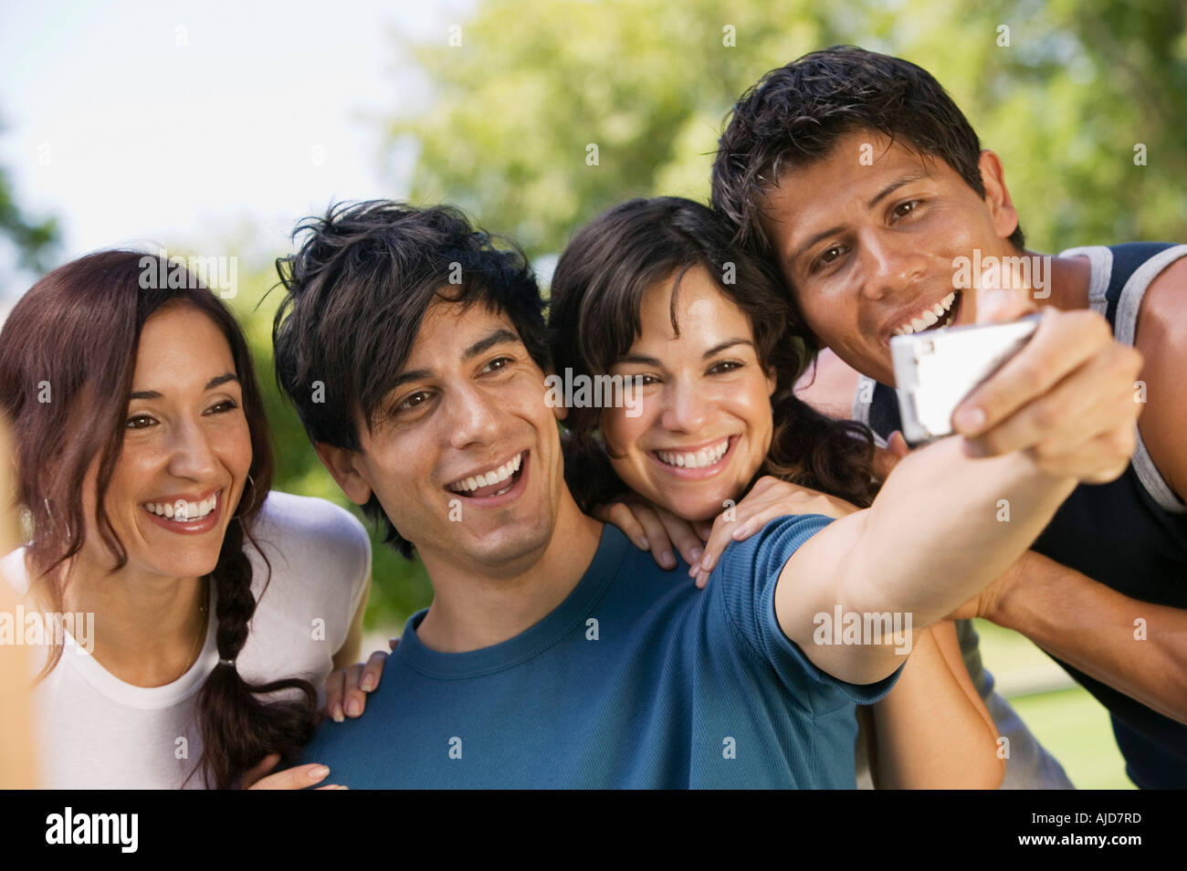 Young man using digital camera, photographing self with three friends. Stock Photo