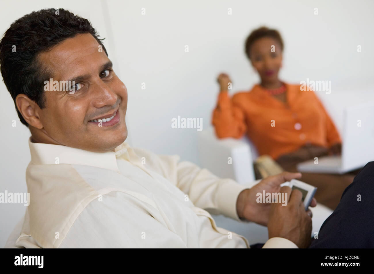 Man sitting on sofa using PDA, portrait, close up Stock Photo
