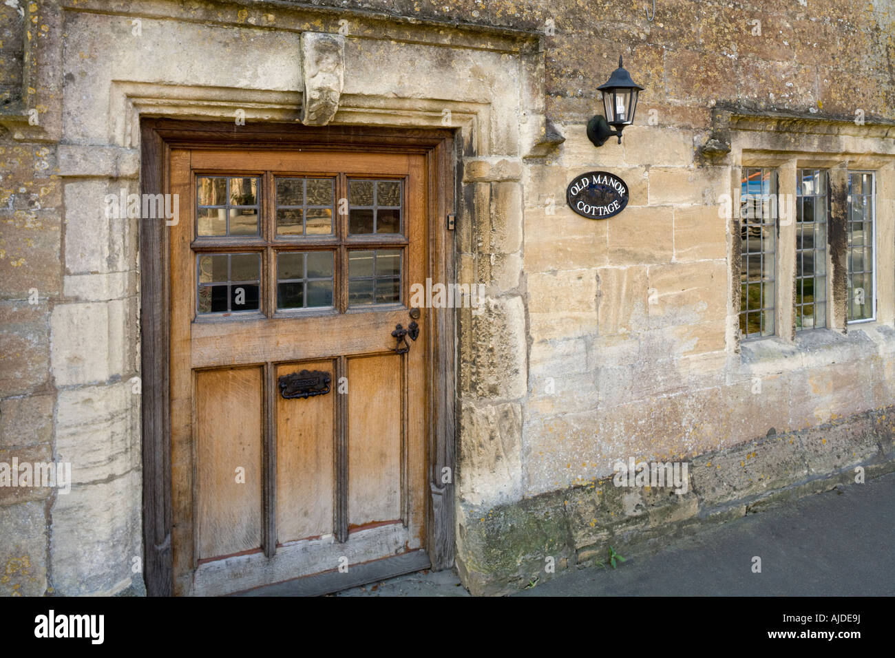 Stone drip mouldings around the door and window of Old Manor Cottage in the Cotswold town of Northleach, Gloucestershire UK Stock Photo