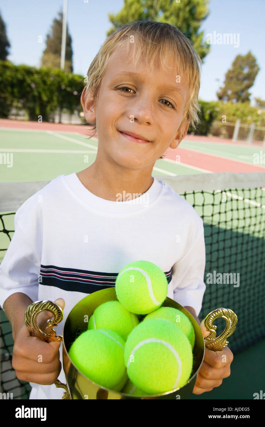 Boy On Tennis Court Holding Trophy Filled With Tennis Balls Portrait Stock Photo Alamy