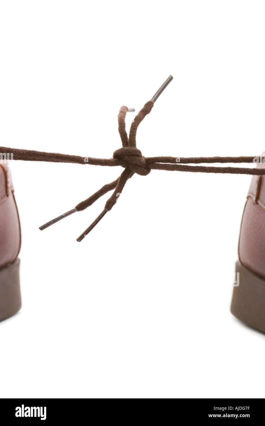 A pair of shoes with tied laces pulling in different directions Stock Photo
