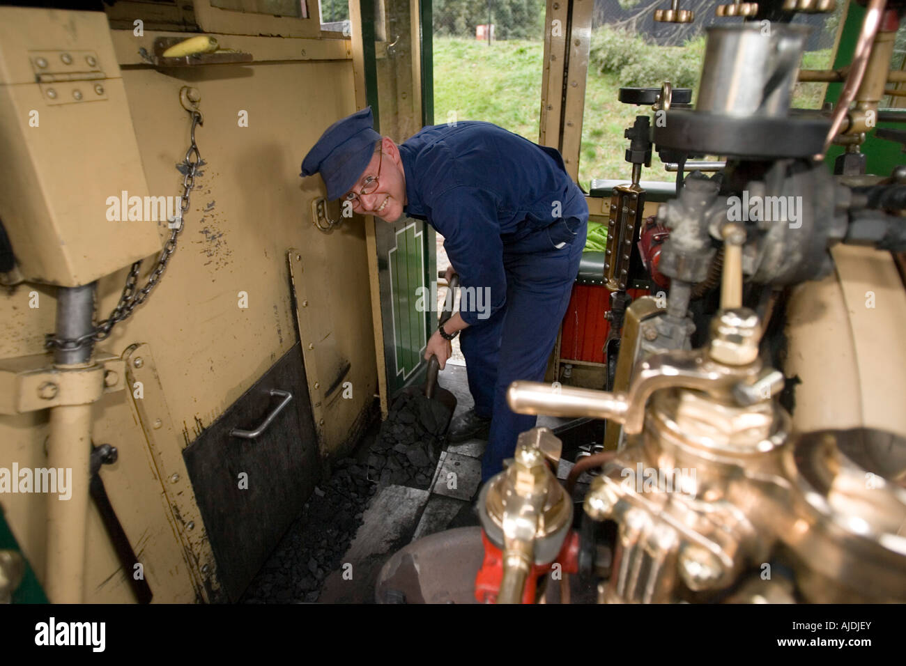 Drivers mate shovels coal into locomotive furnace Puffing Billy historic steam railway Melbourne Australia Stock Photo