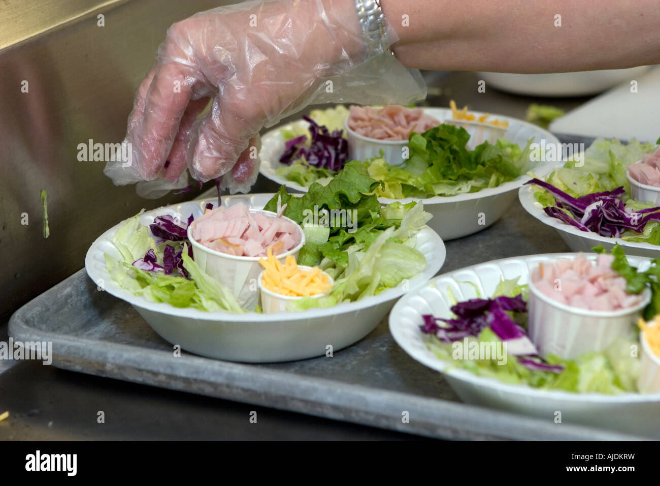 Kitchen staff wear gloves while preparing lunch salads daily in school kitchen Stock Photo Alamy