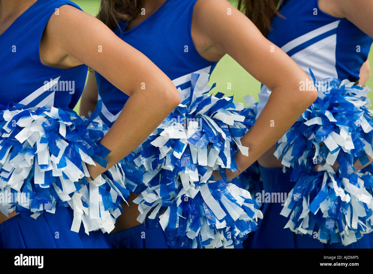 Cheerleaders holding pom-poms, (mid section), (close-up) Stock Photo