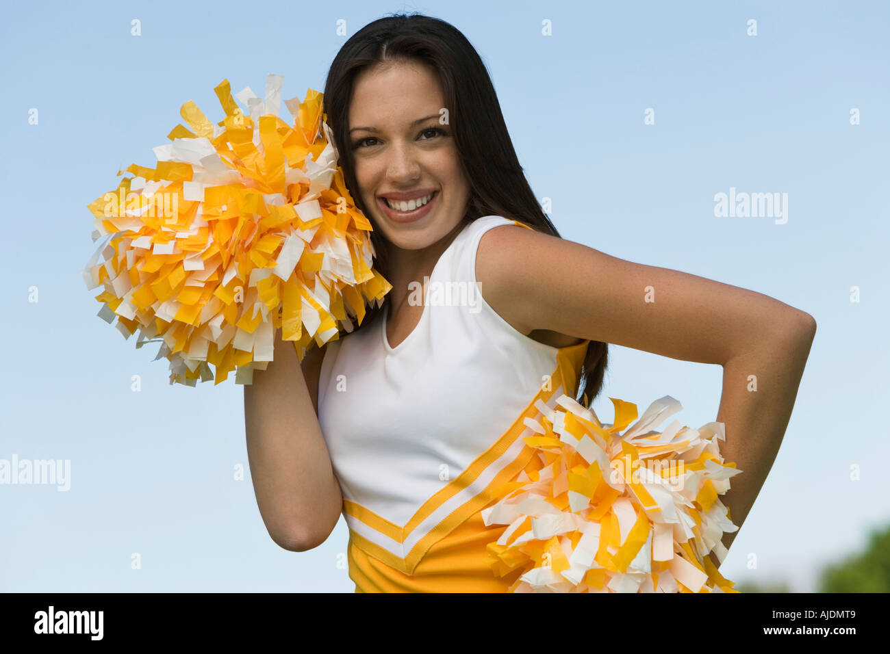 Cheerleader In Blue And Yellow Uniform With Pom Poms Stock