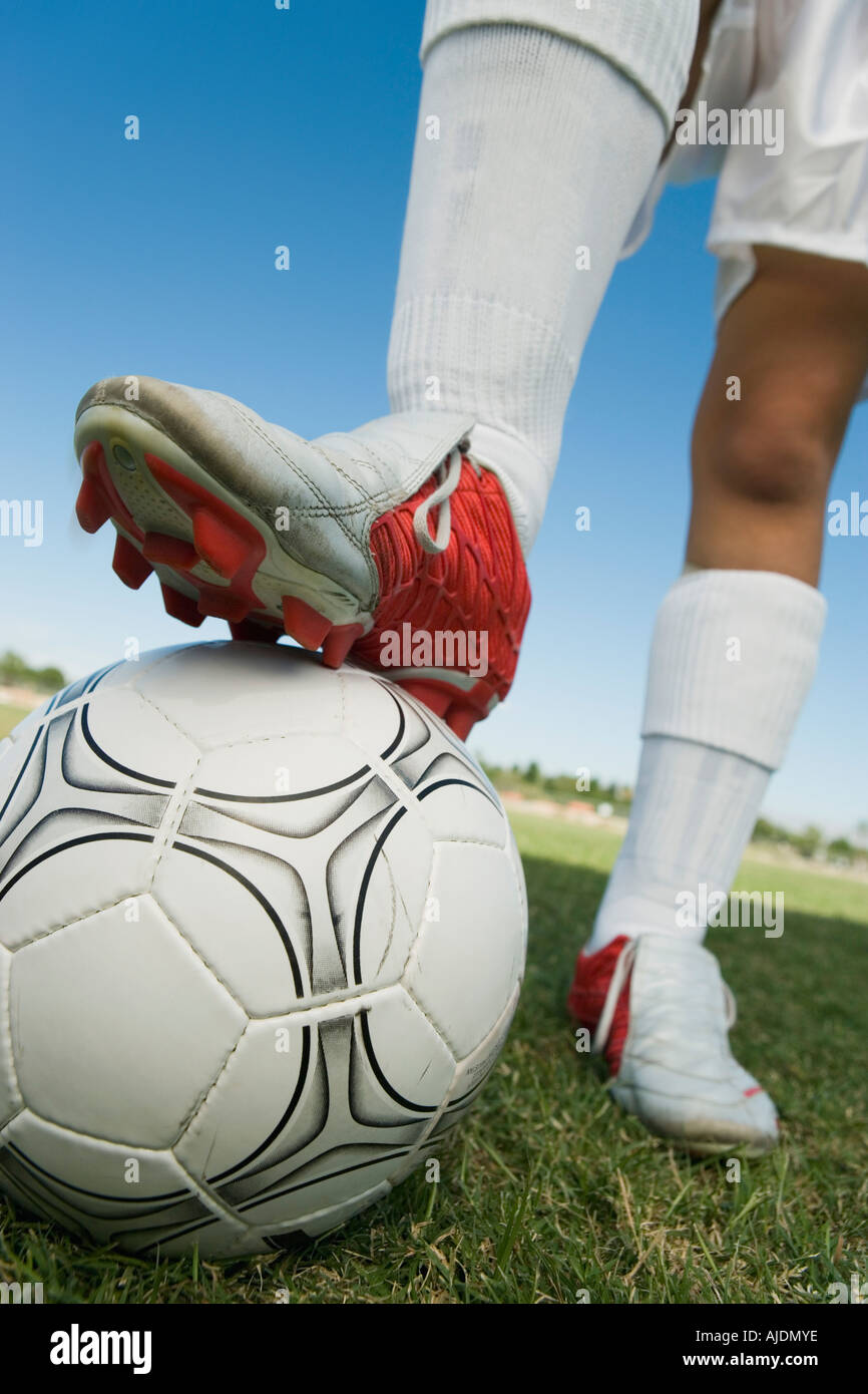 Soccer player (1317) standing on ball, low section Stock Photo Alamy