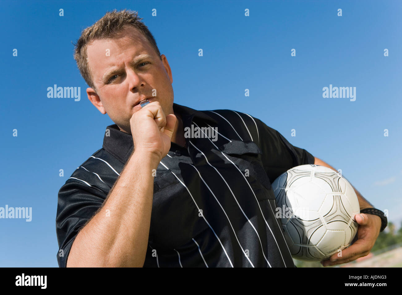 Soccer referee blowing whistle, portrait Stock Photo