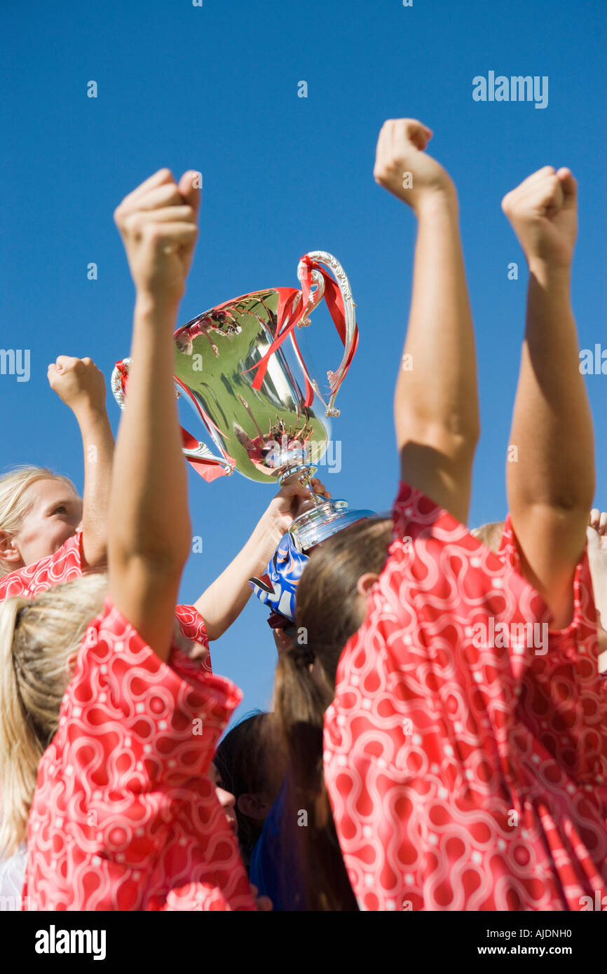 Girls' soccer team (13-17) holding trophy, side view Stock Photo