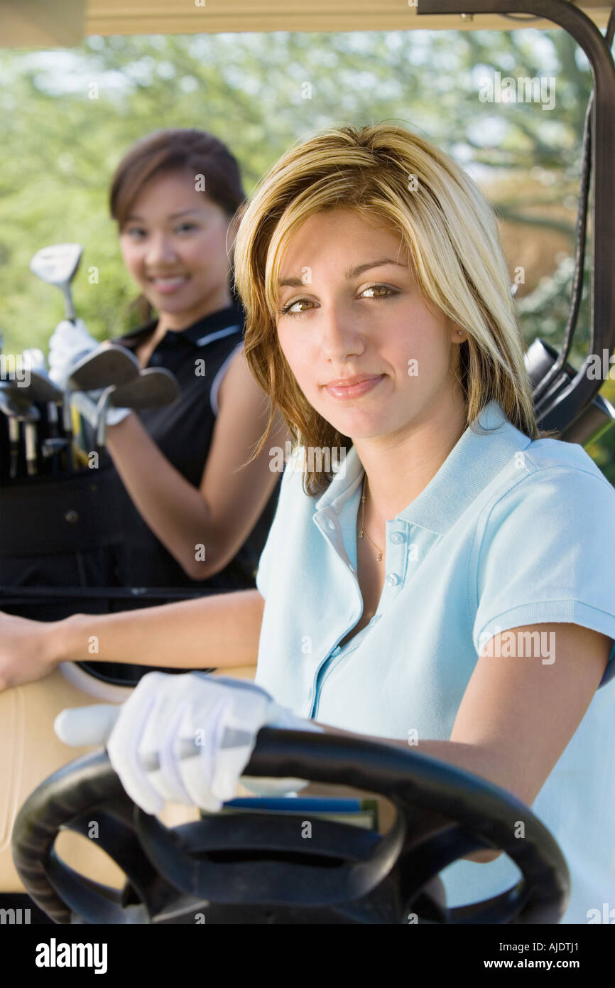 Two female golfers sitting in golf cart Stock Photo Alamy
