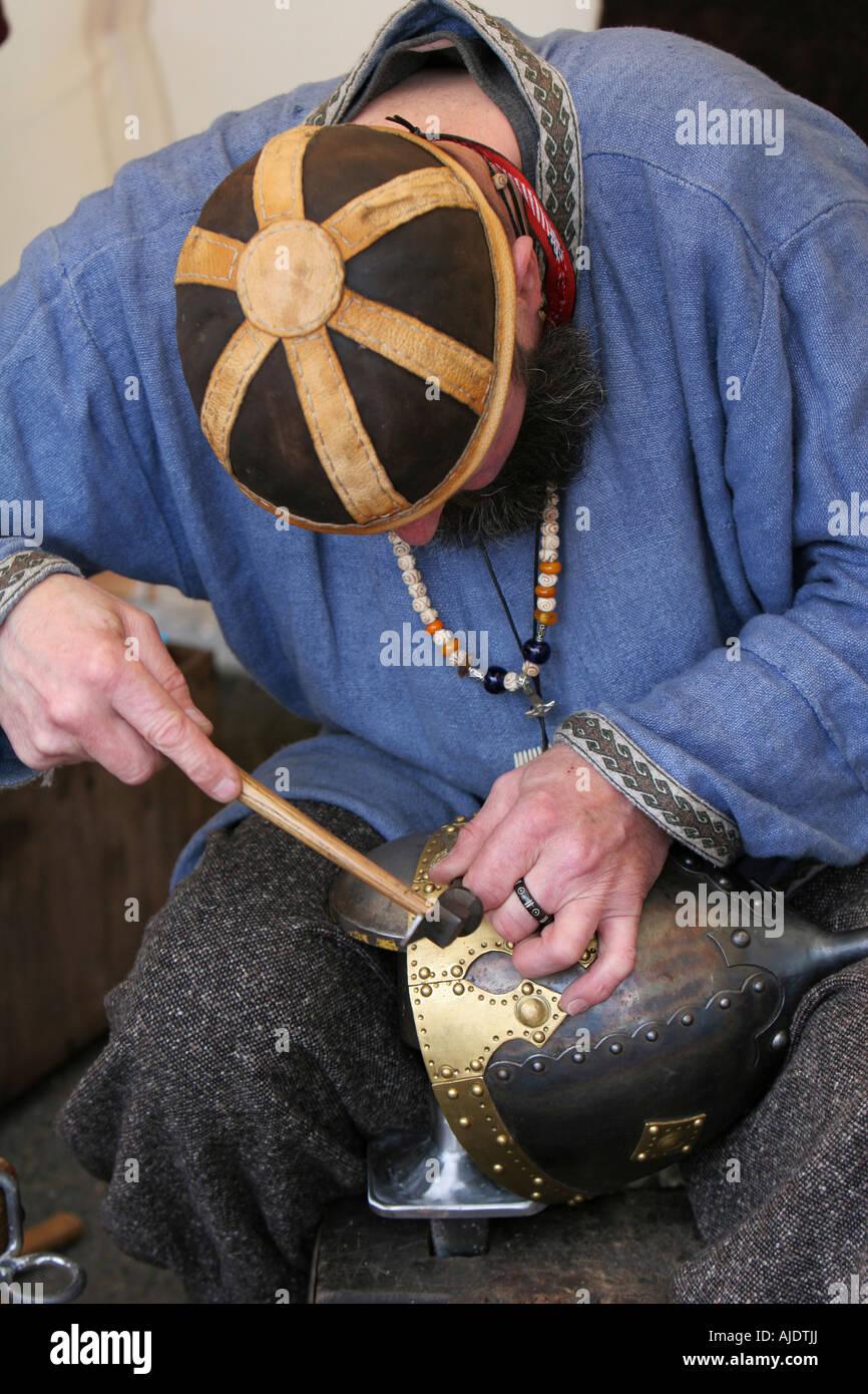 A craftsman chiseling inscription into a medieval soldiers helmet Stock Photo