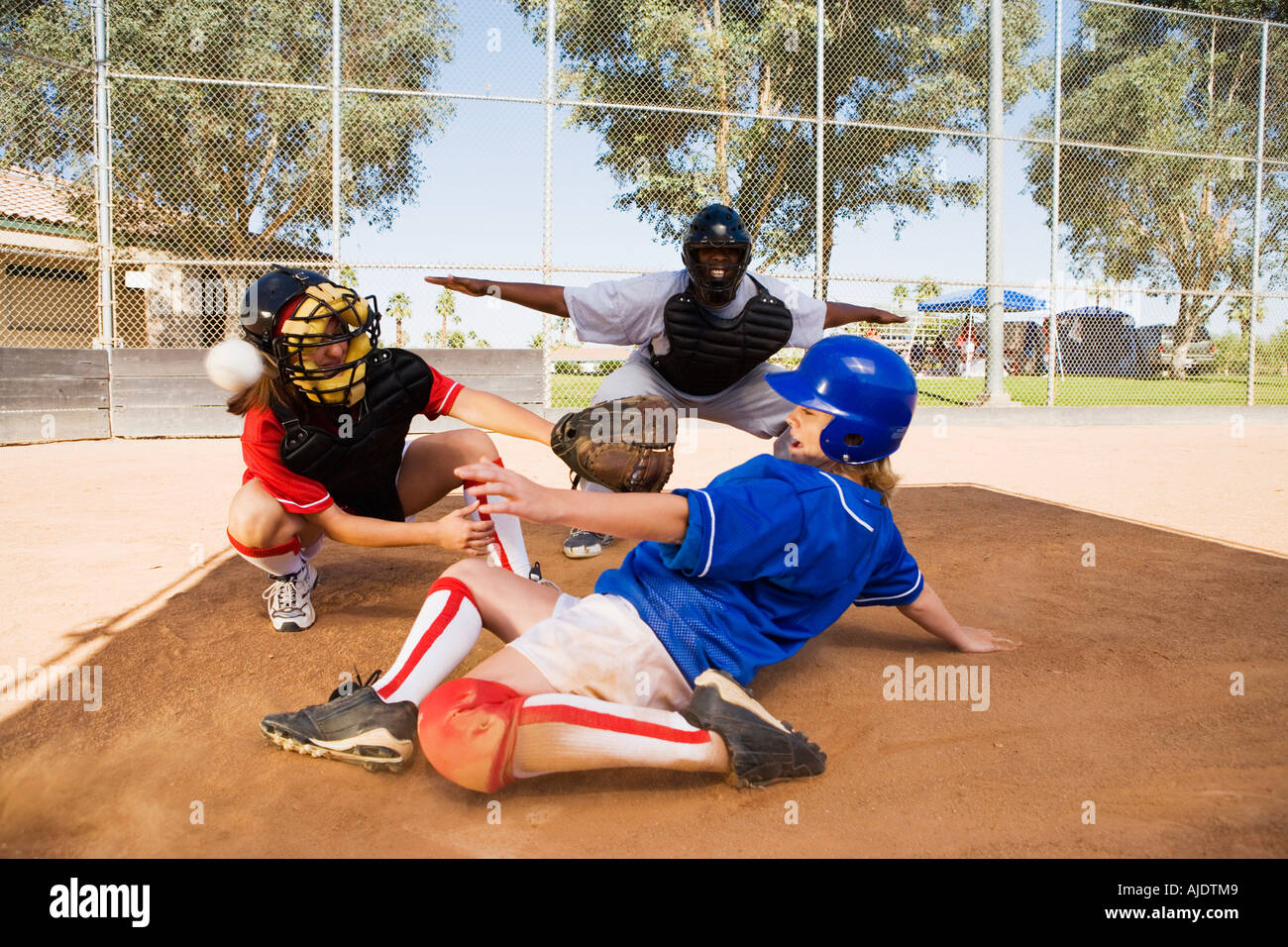 Softball player slideing into home plate Stock Photo