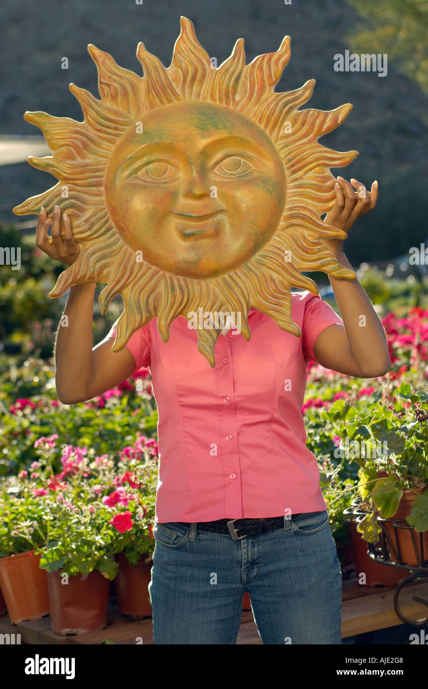 Woman holding model sun over face at plant nursery Stock Photo - Alamy