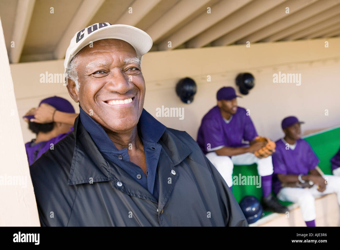 Baseball coach in dugout, smiling, (portrait Stock Photo Alamy
