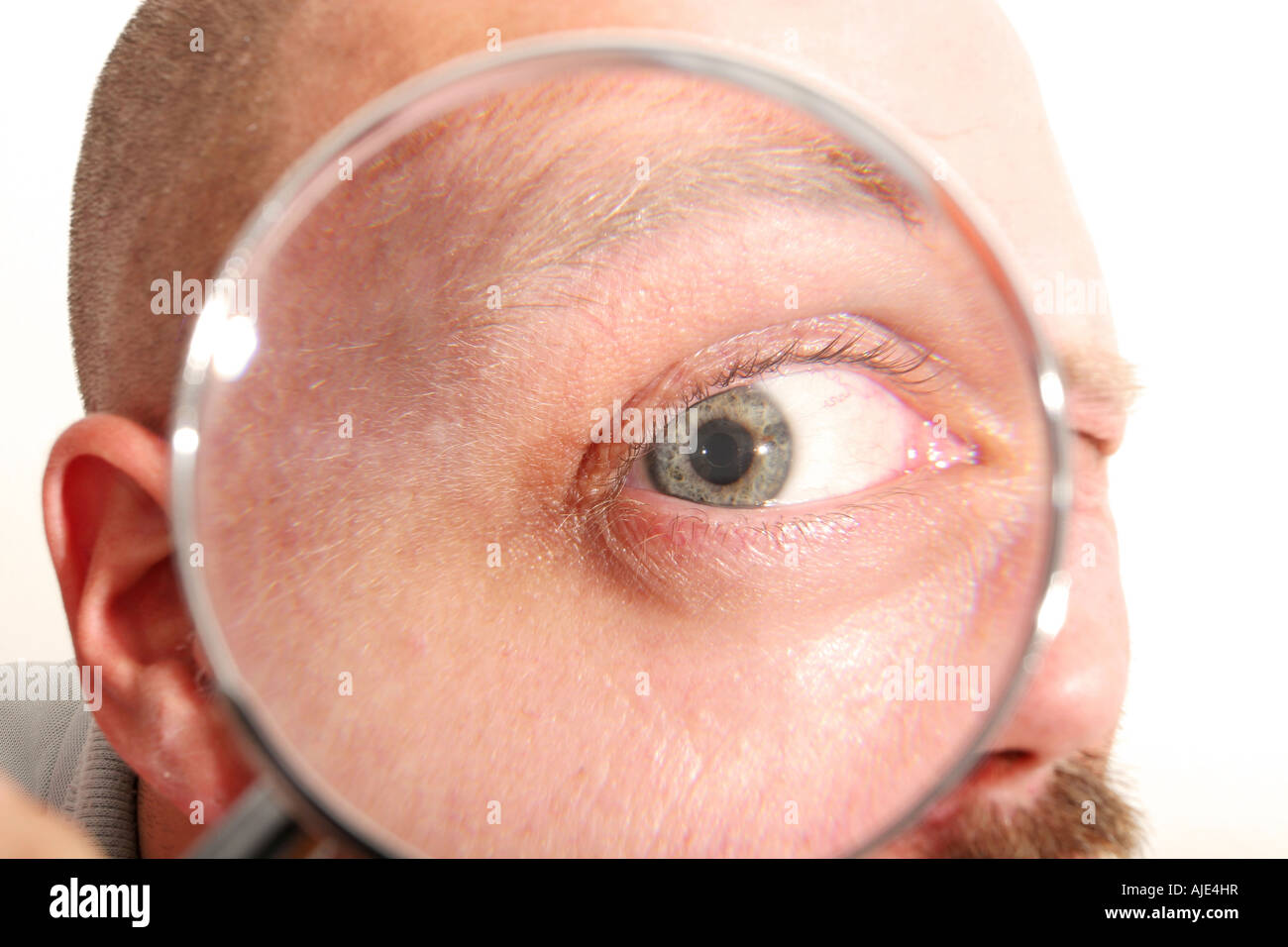 man looking through magnifying glass eye magnified Stock Photo Alamy