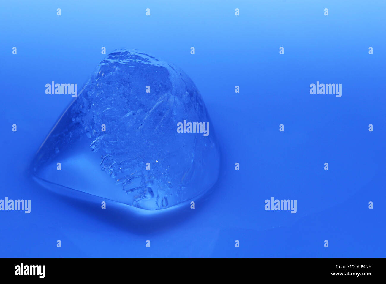 cold ice cube melting on blue background Stock Photo - Alamy