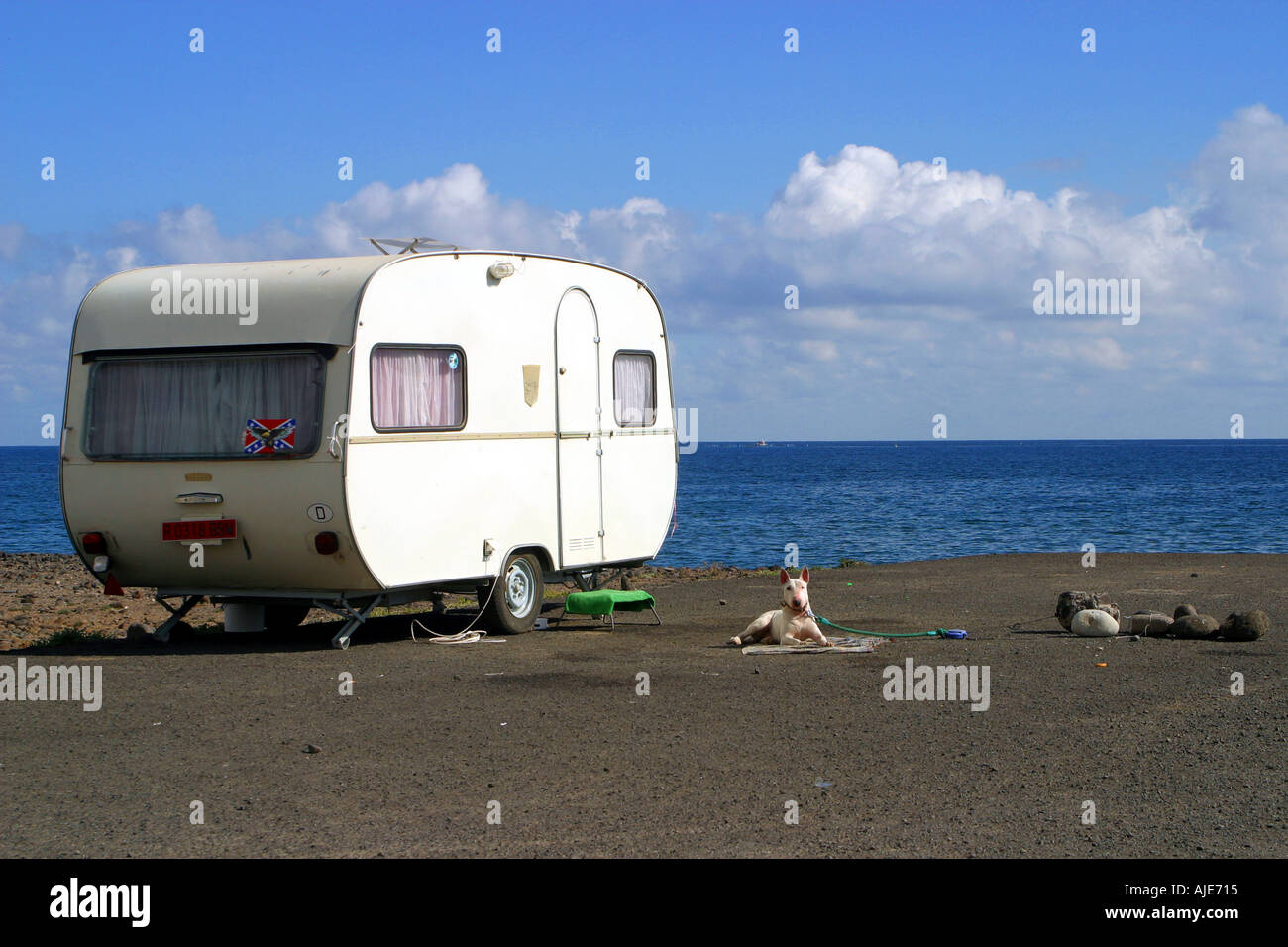 A dog guards a caravan near the beach of Playa De Melenar Gran Canaria The Canary Islands Spain Stock Photo