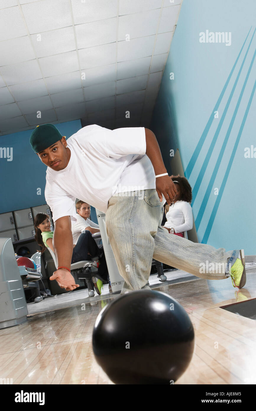 Young man releasing bowling ball, portrait Stock Photo Alamy