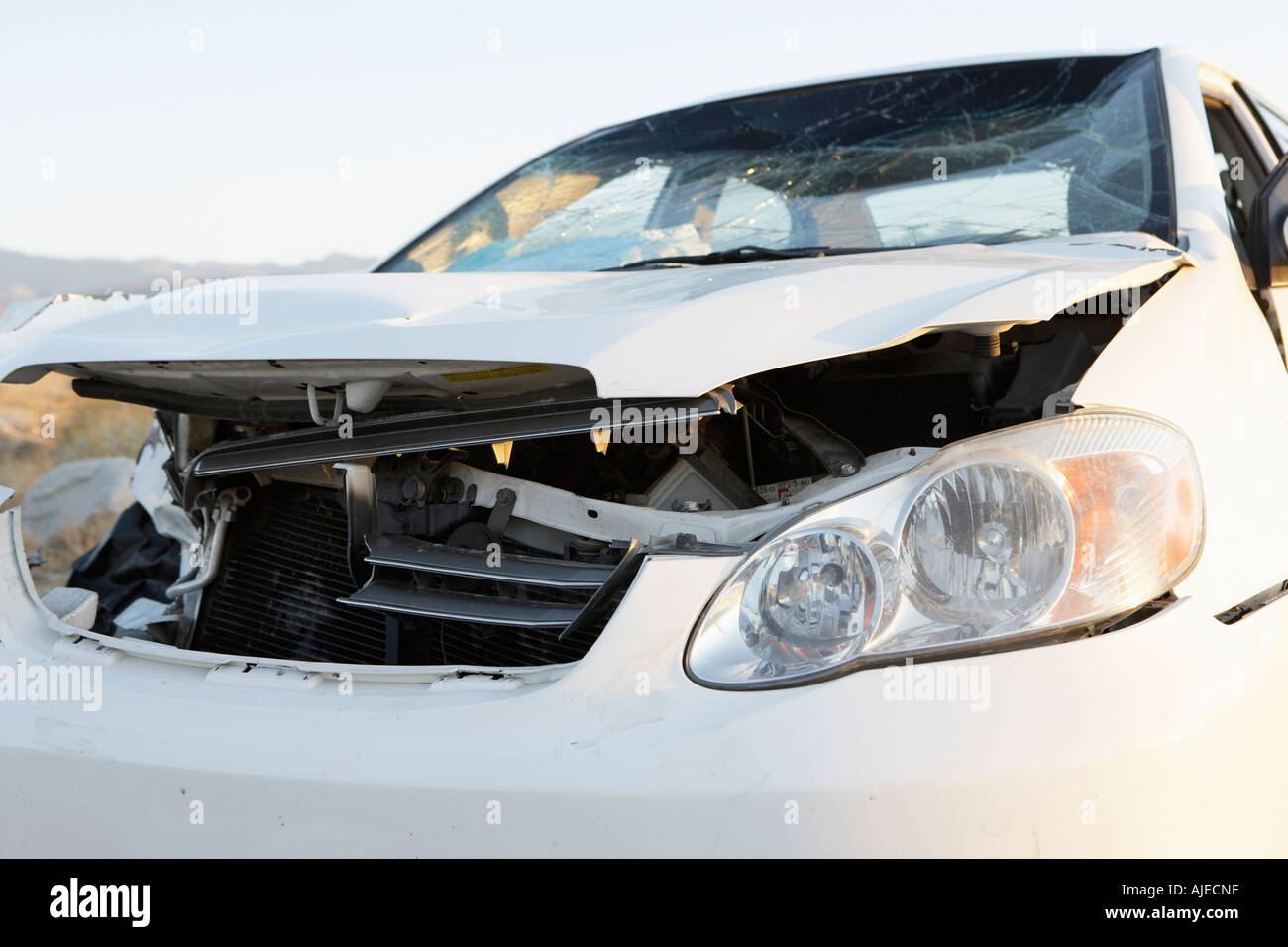 Front end of wrecked car on desert highway Stock Photo - Alamy