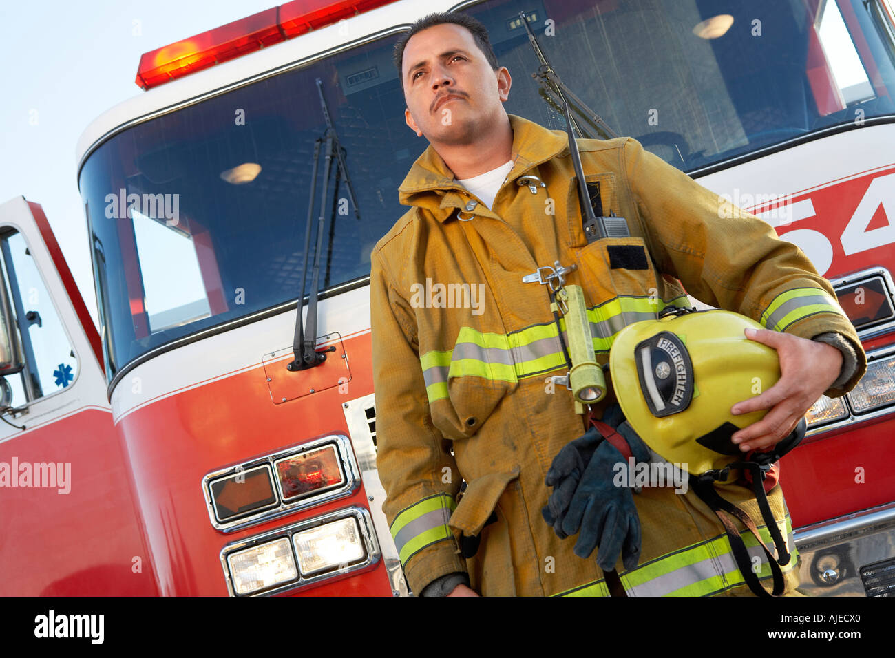 Fire fighter standing in front of fire engine Stock Photo - Alamy