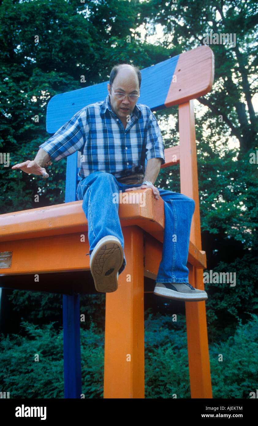 Man Sitting in Giant Adirondack Chair Stock Photo