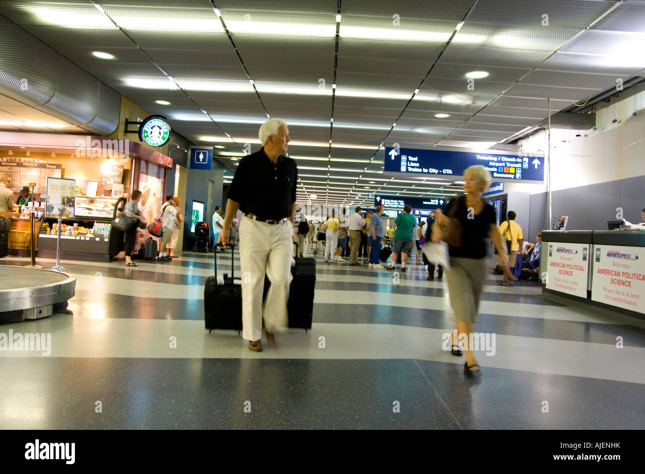 Travelers walk with their luggage through the airport Stock Photo Alamy
