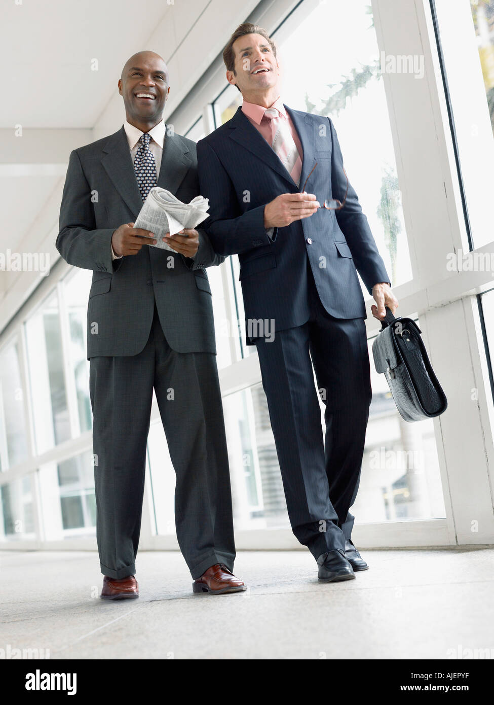 Two businessmen walking side by side hi-res stock photography and ...