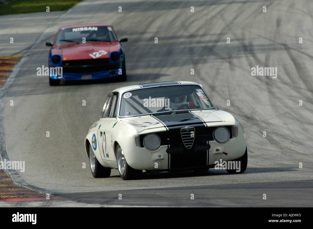 A 1967 Alfa Romeo GTV followed by a 1972 Datsun 240Z at the 2006 Kohler International Challenge with Brian Redman Stock Photo