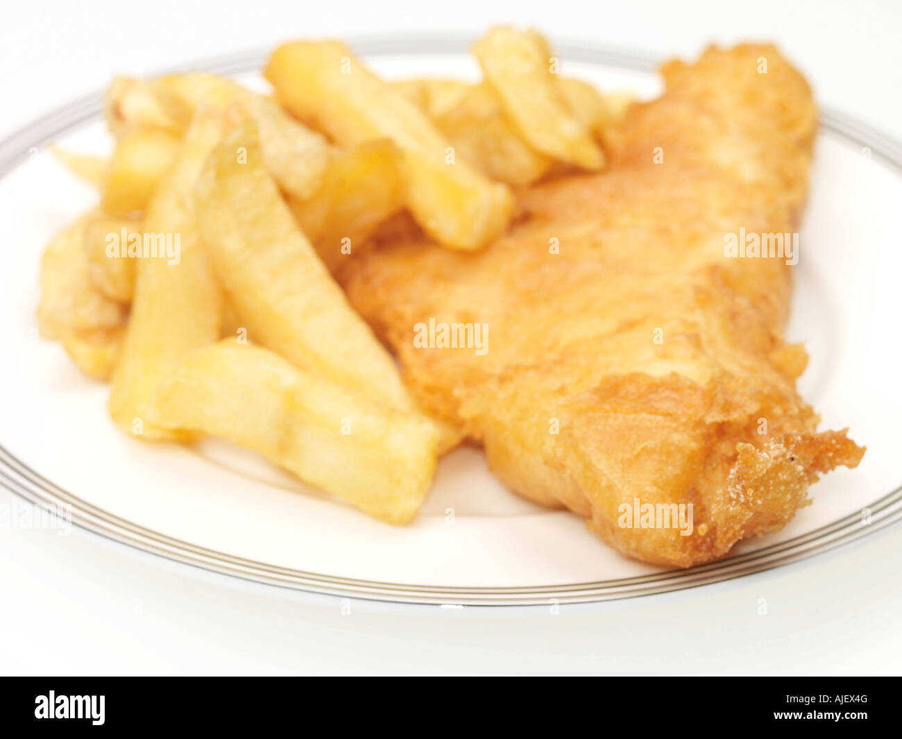 Plate Of Shop Bought Takeaway Cod or Haddock Fish and Chips Against A White Background with A Clipping Path And No People Stock Photo