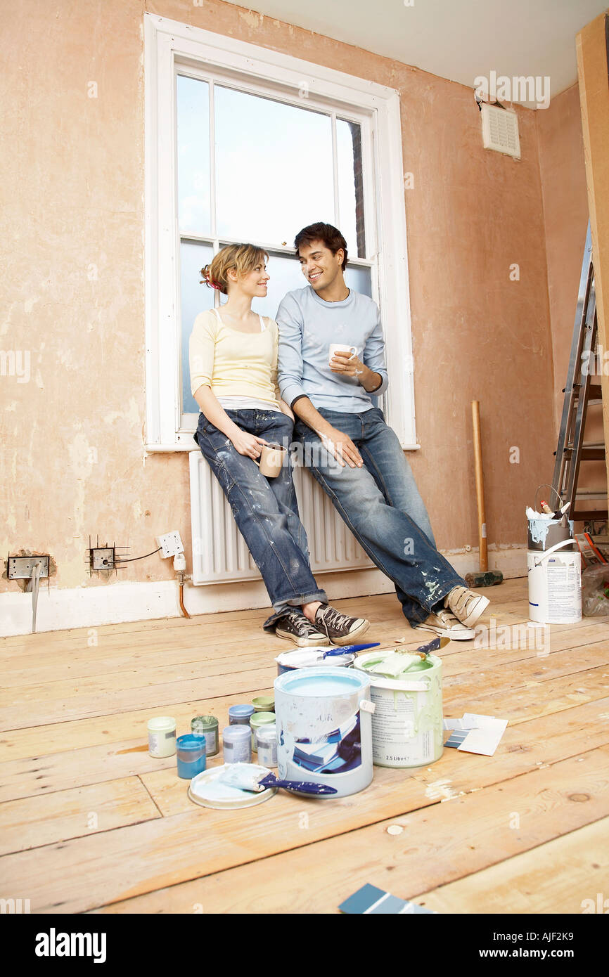 Couple taking a break from painting living room Stock Photo Alamy
