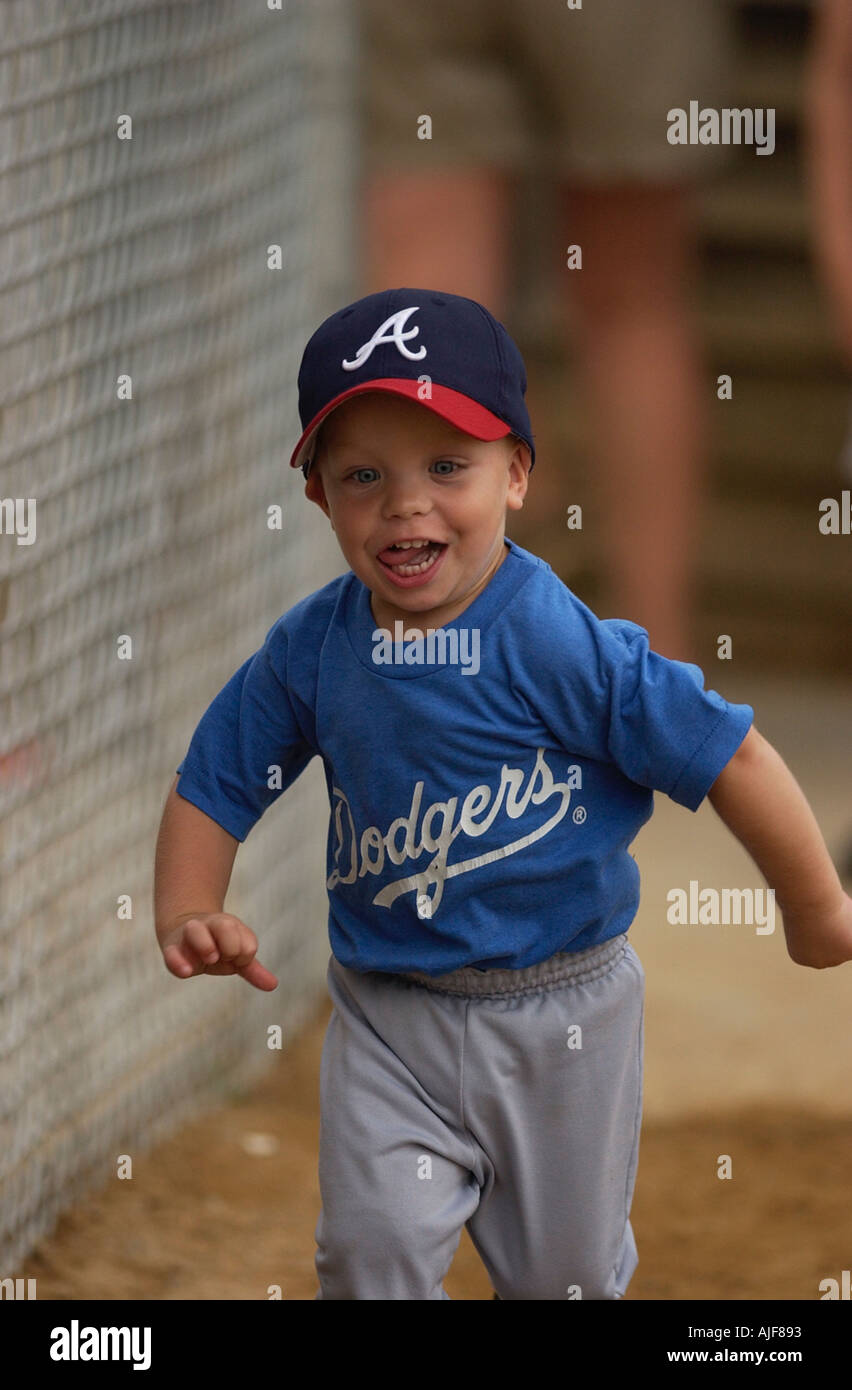 Toddler runs around the bases after a youth baseball game Stock Photo