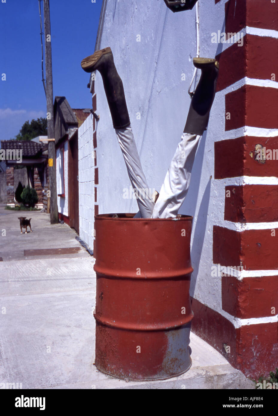 Legs sticking out of oil drum outside Irish bar Stock Photo Alamy