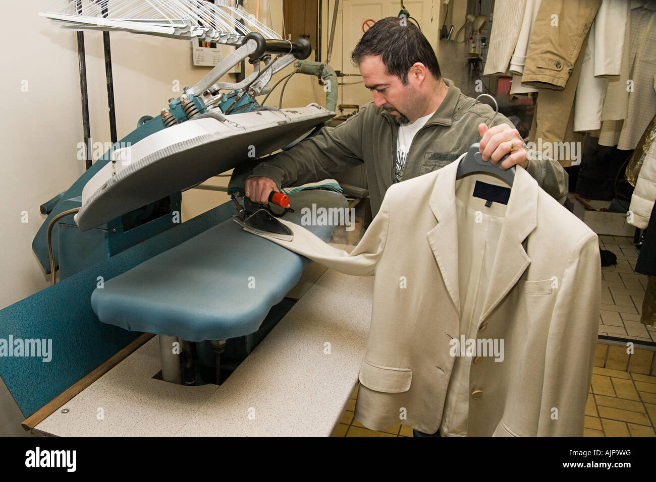 Man ironing jacket Stock Photo Alamy