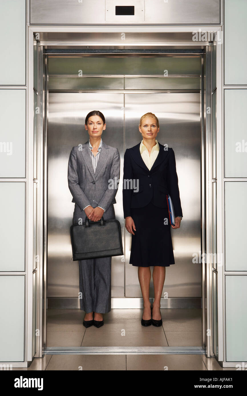 Businesswomen Side by Side in Elevator, portrait, front view Stock Photo