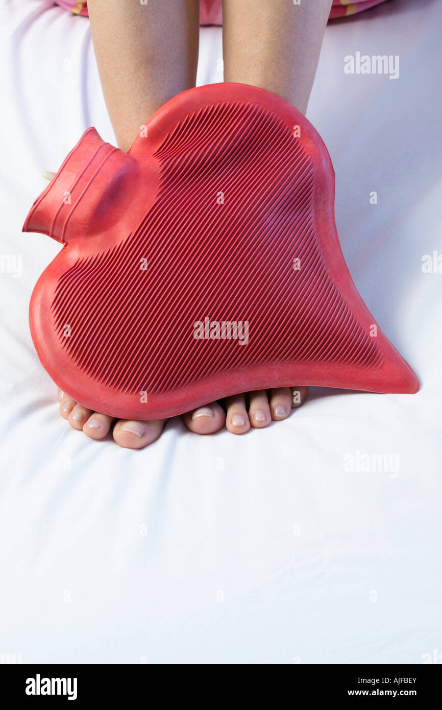 Feet and a heart shaped hot water bottle Stock Photo