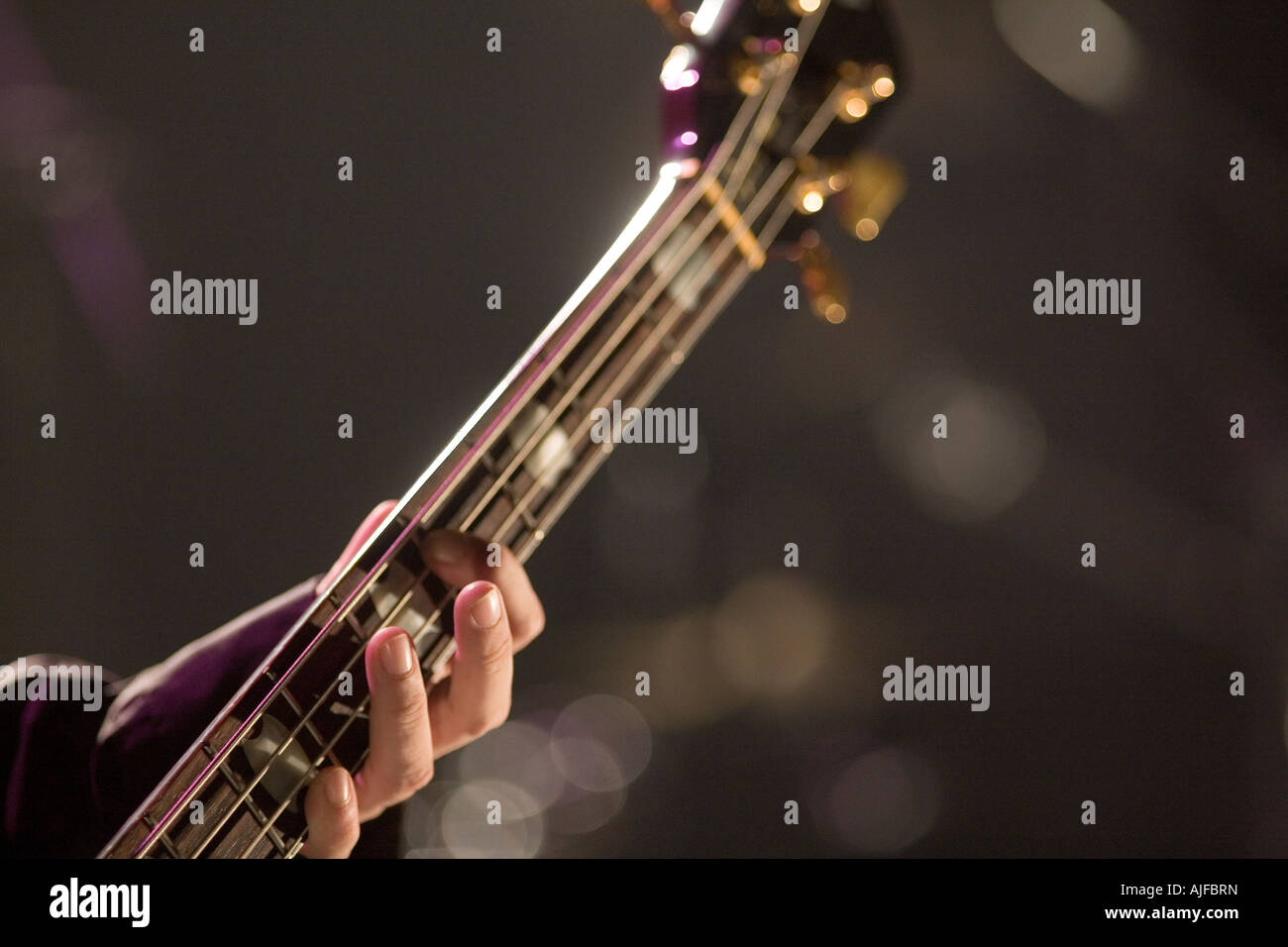 Young man playing bass guitar on stage Stock Photo