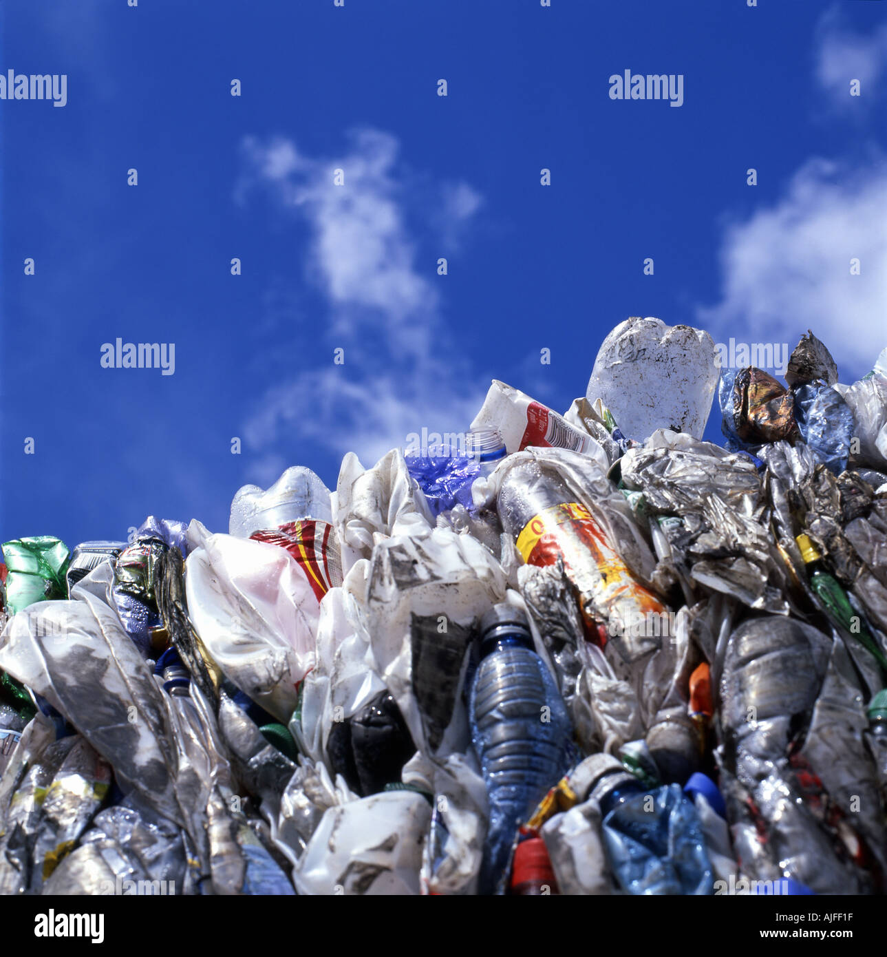 Plastic bottles, food packaging bags being recycled and a blue sky at