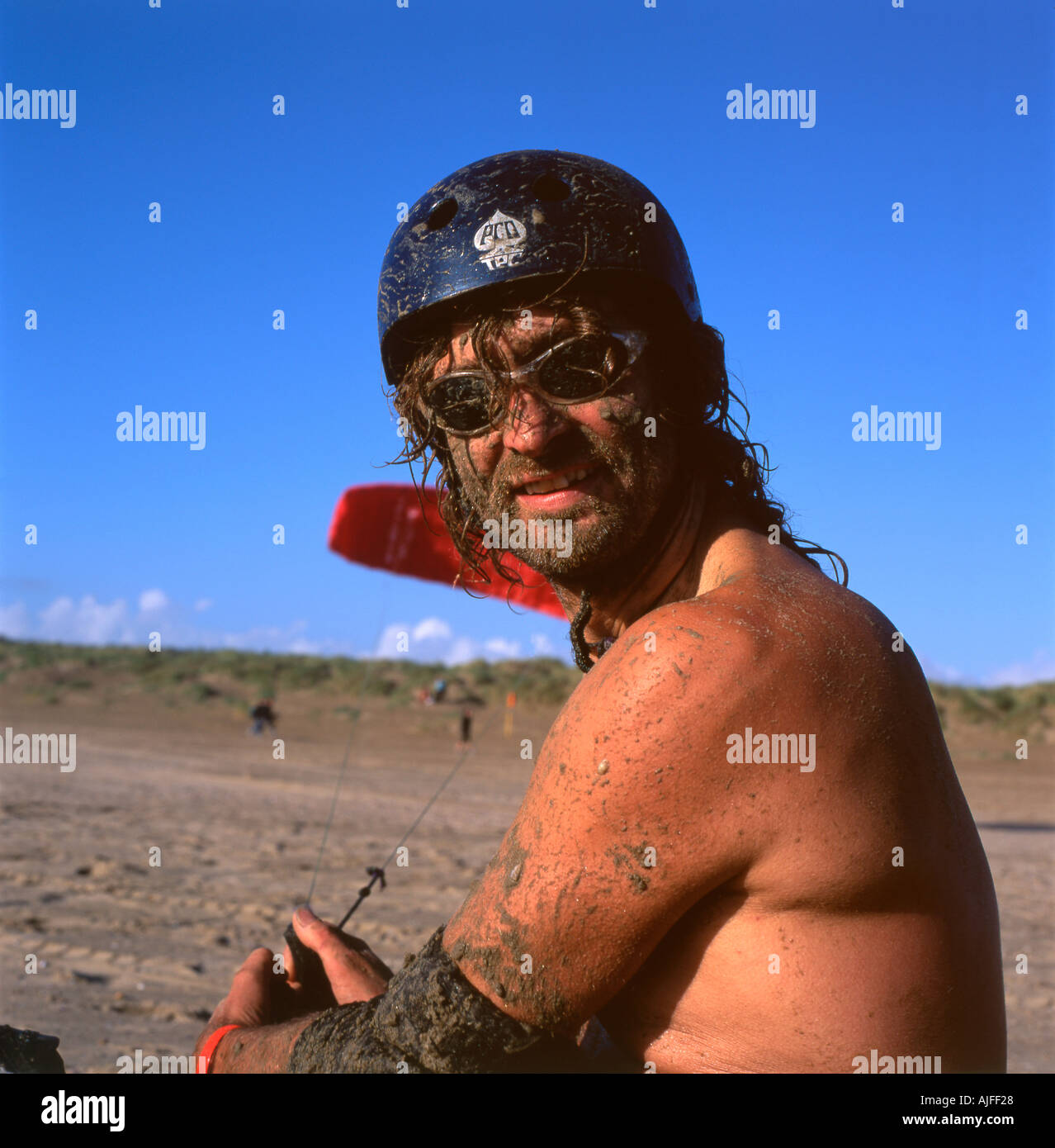 Portrait of a man with sand splattered face wearing sunglasses whilst kite buggying on Pembrey Sands Carmarthenshire  Wales UK   KATHY DEWITT Stock Photo