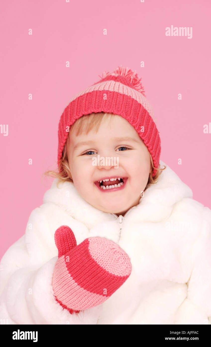 Two year old girl in fuzzy jacket mittens and hat Stock Photo