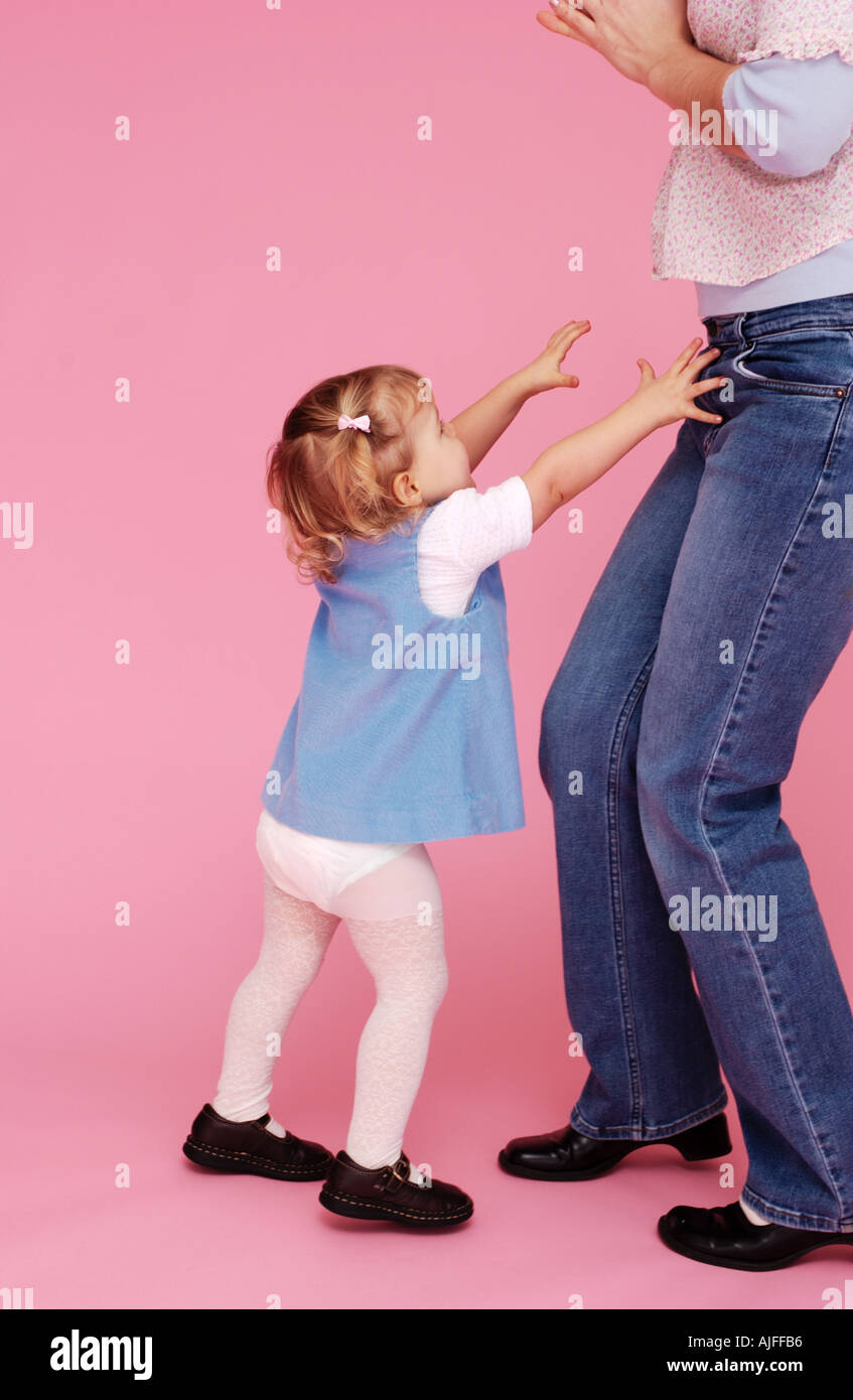 Two year old toddler wants mom to pick her up Stock Photo Alamy