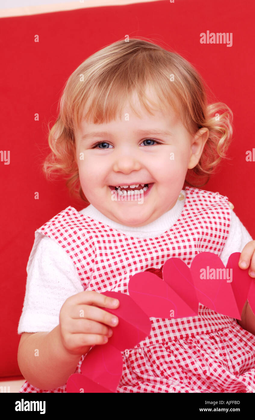 Two year old girl holding paper hearts Stock Photo