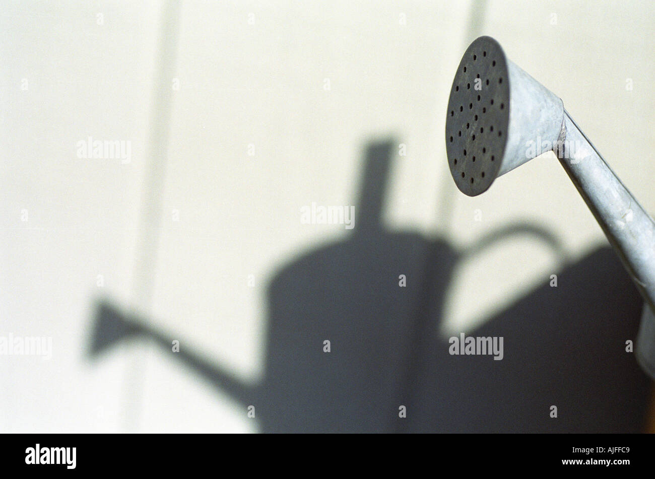 Watering can spout and shadow of watering can in background Stock Photo