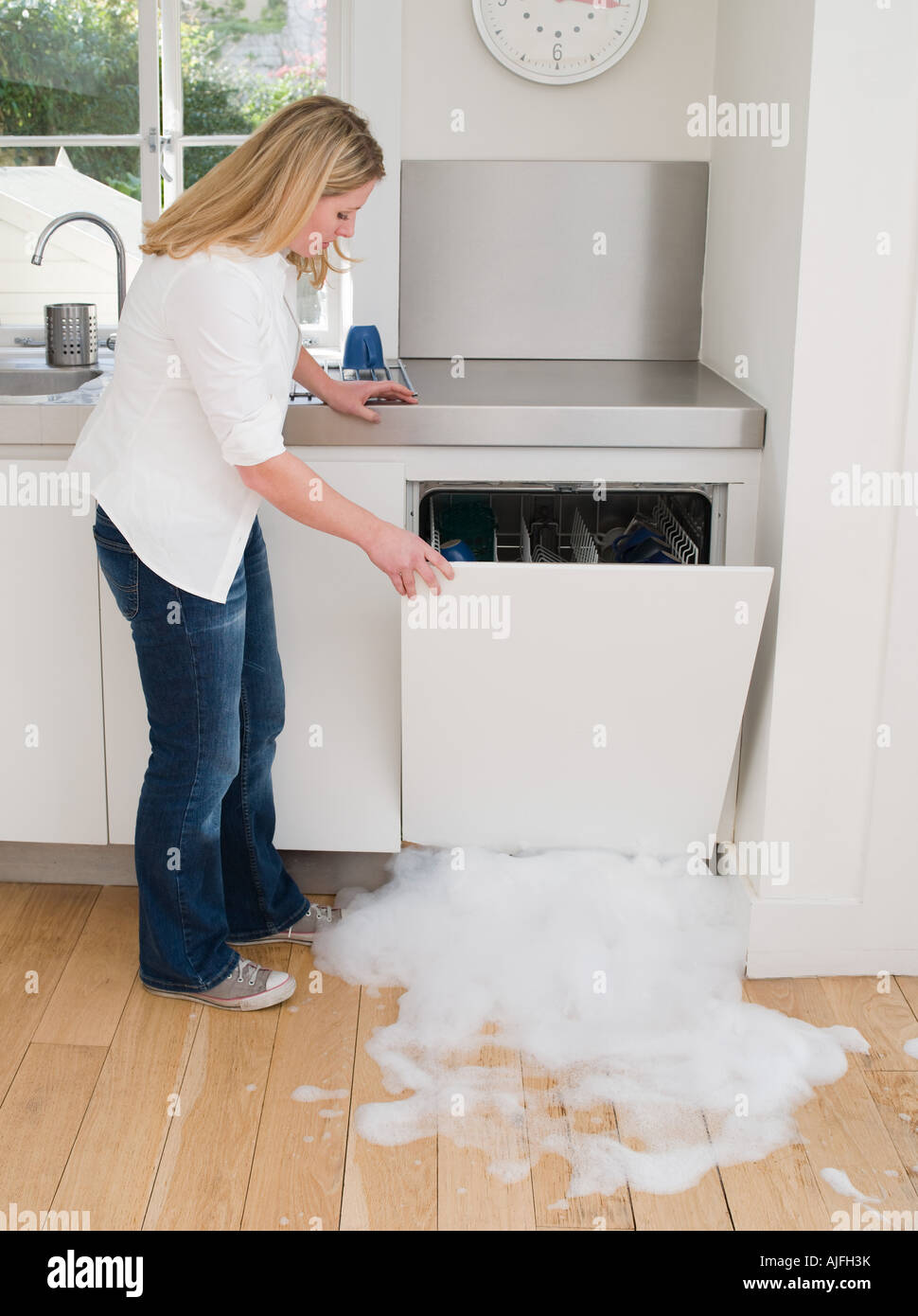 Woman opening a leaking dishwasher Stock Photo Alamy