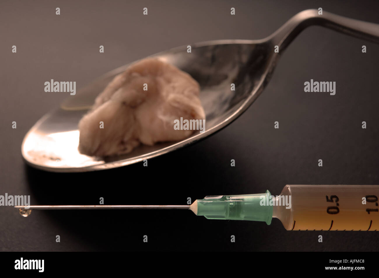 heroin in a hypodermic needle after being cooked on a spoon Stock Photo
